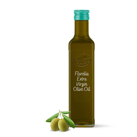 A bottle of Florelia extra virgin olive oil with a green cap and label displaying the brand name. There are also some olives and a olive branch to the left of the bottle.